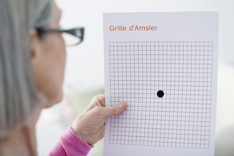 Woman screening for AMD with an Amsler Grid