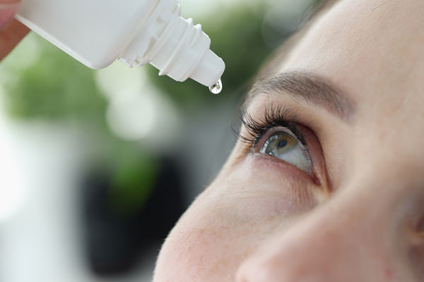 Woman using eye drops